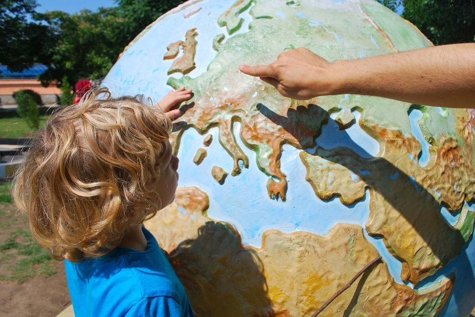 Child pointing to a globe